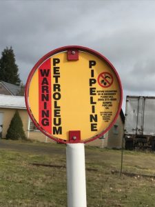 One of many "warning, petroleum pipeline" signs  running through a nearby town built over what was once Nisqually prairie land. (Credit, Tori Chapman). 