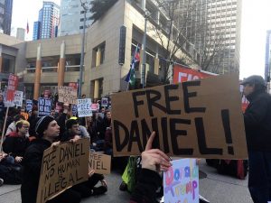 A protestor at a rally in Seattle holding up a sign that reads "Free Daniel". Daniel Ramirez Medina was taken into custody by ICE who claims he is "gang affiliated"(Credit: The Stranger) 