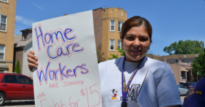 Home Care Worker demonstrates with a sign that reads, "Home Care workers are joining the Fight for $15." (Credit: Fight for 15 Home Care).