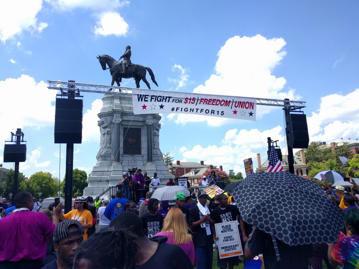 Fight for 15 marched on a statue of Robert E. Lee in Richmond, VA, once the capitol of the Confederacy. Protesters carry "Black Lives Matter, Fight for 15, Immigrant Justice" signs. (Credit: Alan Pyke).