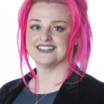 Smiling person with bright pink hair